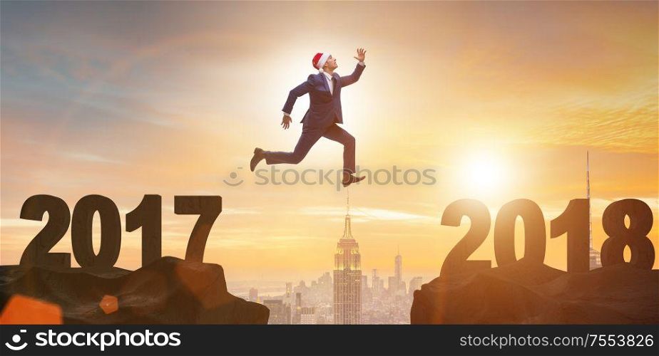 The businessman in santa hat jumping from 2017 to 2018. Businessman in santa hat jumping from 2017 to 2018