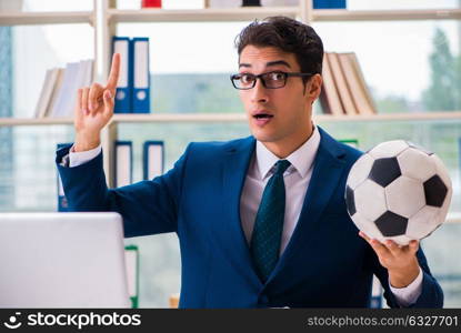 The businessman playing football in the office. Businessman playing football in the office