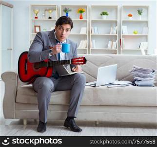 The businessman playing guitar at home. Businessman playing guitar at home