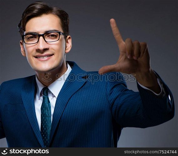 The businessman pressing virtual buttons on gray background. Businessman pressing virtual buttons on gray background