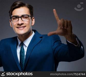 The businessman pressing virtual buttons on gray background. Businessman pressing virtual buttons on gray background