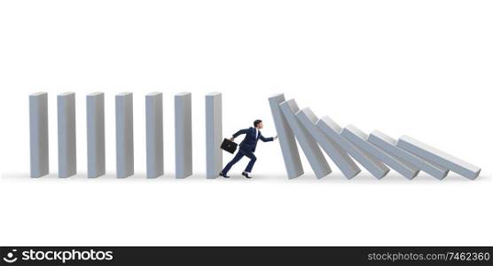 The businessman preventing domino effect in business concept. Businessman preventing domino effect in business concept