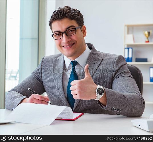 The businessman signing business documents in office. Businessman signing business documents in office