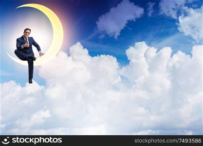 The businessman sitting on the crescent moon. Businessman sitting on the crescent moon