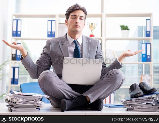 The businessman sitting on top of desk in office. Businessman sitting on top of desk in office