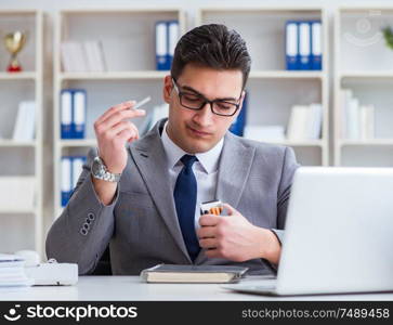 The businessman smoking in office at work. Businessman smoking in office at work