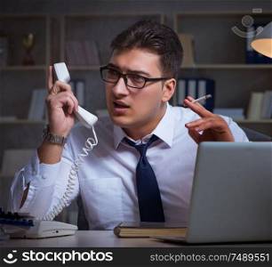 The businessman speaking on phone and smoking in office. Businessman speaking on phone and smoking in office