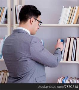 The businessman student reading a book studying in library. Businessman student reading a book studying in library