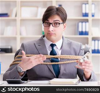 The businessman tied up with rope in office. Businessman tied up with rope in office