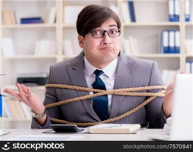 The businessman tied up with rope in office. Businessman tied up with rope in office