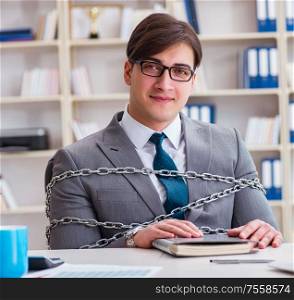 The businessman tied with chains to his work. Businessman tied with chains to his work