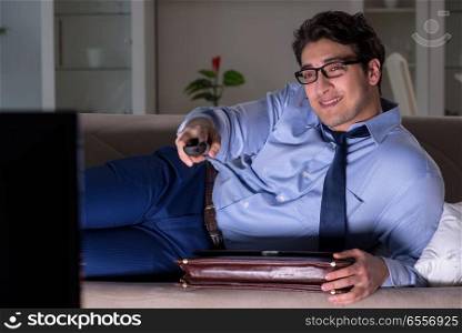 The businessman watching tv at night late. Businessman watching tv at night late