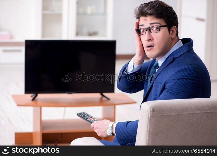 The businessman watching tv in the office. Businessman watching tv in the office