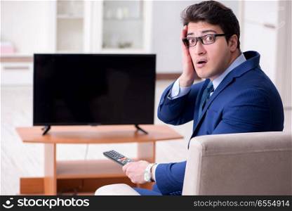 The businessman watching tv in the office. Businessman watching tv in the office