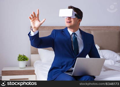 The businessman wearing a virtual reality headset in the bedroom. Businessman wearing a virtual reality headset in the bedroom