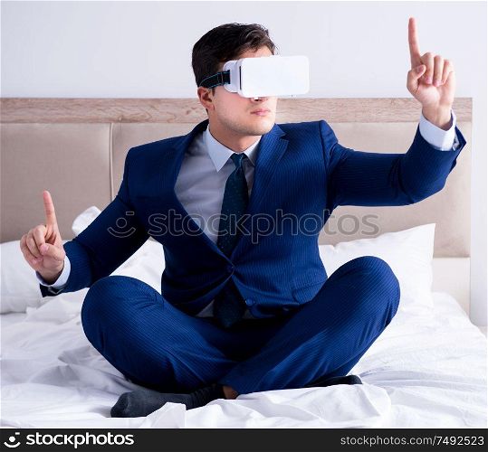 The businessman wearing a virtual reality headset in the bedroom. Businessman wearing a virtual reality headset in the bedroom