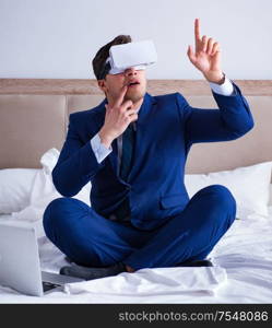 The businessman wearing a virtual reality headset in the bedroom. Businessman wearing a virtual reality headset in the bedroom