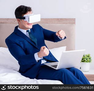 The businessman wearing a virtual reality headset in the bedroom. Businessman wearing a virtual reality headset in the bedroom