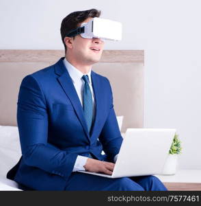 The businessman wearing a virtual reality headset in the bedroom. Businessman wearing a virtual reality headset in the bedroom