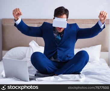 The businessman wearing a virtual reality headset in the bedroom. Businessman wearing a virtual reality headset in the bedroom