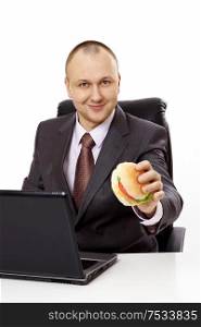 The businessman with a hamburger and the laptop on a white background