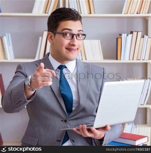 The businessman with a laptop working in the library. Businessman with a laptop working in the library