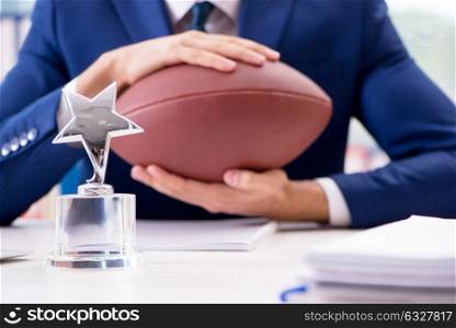 The businessman with american football in office. Businessman with american football in office