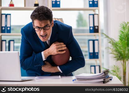 The businessman with american football in office. Businessman with american football in office