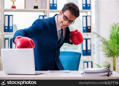 The businessman with boxing gloves angry in office. Businessman with boxing gloves angry in office