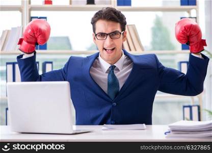 The businessman with boxing gloves angry in office. Businessman with boxing gloves angry in office