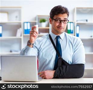 The businessman with broken arm working in office. Businessman with broken arm working in office