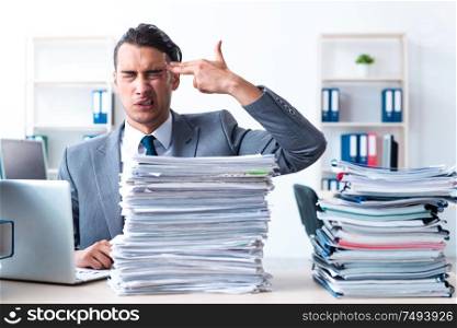 The businessman with heavy paperwork workload. Businessman with heavy paperwork workload