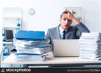 The businessman with heavy paperwork workload. Businessman with heavy paperwork workload