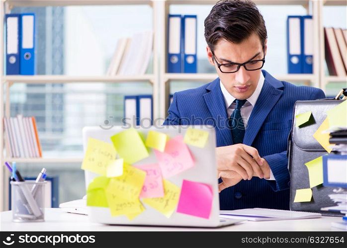 The businessman with reminder notes in multitasking concept. Businessman with reminder notes in multitasking concept