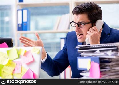 The businessman with reminder notes in multitasking concept. Businessman with reminder notes in multitasking concept