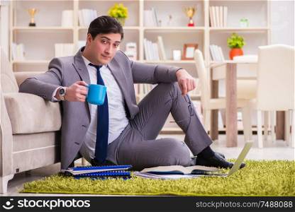 The businessman working on the floor at home. Businessman working on the floor at home