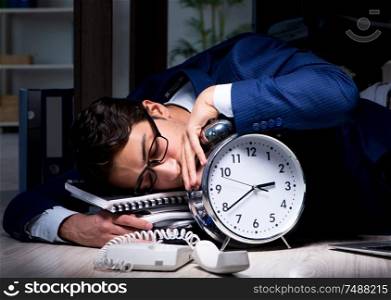 The businessman working overtime long hours late in office. Businessman working overtime long hours late in office