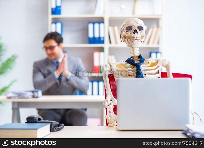 The businessman working with skeleton in office. Businessman working with skeleton in office