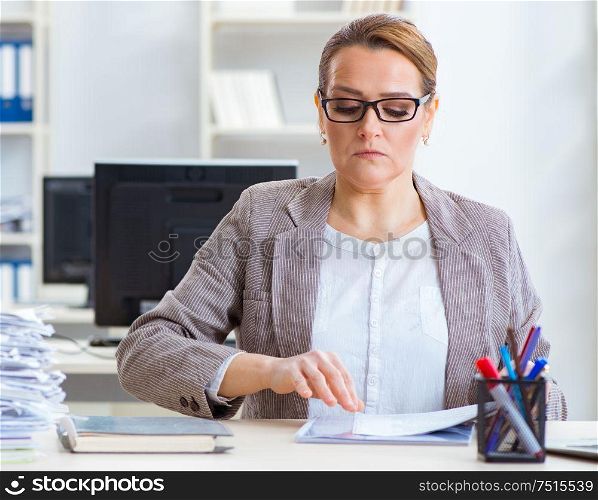 The businesswoman very busy with ongoing paperwork. Businesswoman very busy with ongoing paperwork