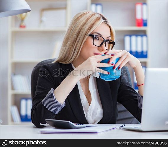 The businesswoman working on laptop at the desk in the office. Businesswoman working on laptop at the desk in the office