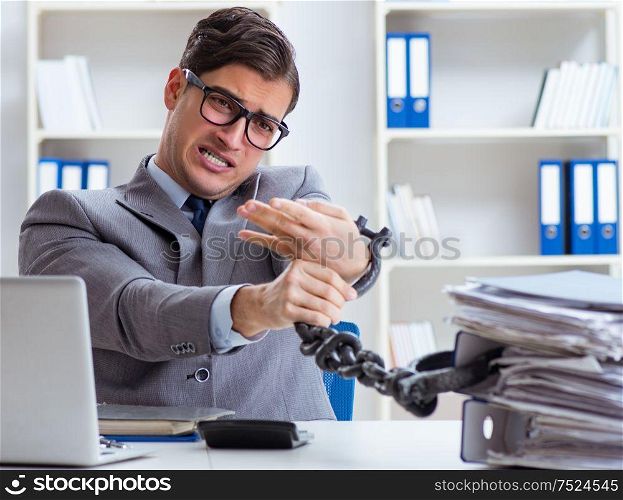 The busy employee chained to his office desk. Busy employee chained to his office desk