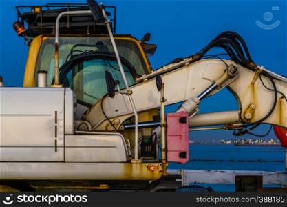 the cabin of a excavator with arm, old rusty digger machine, construction and ground mover equipment