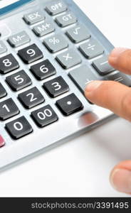 The calculator and a hand of the man. Pressing of a key of the calculator