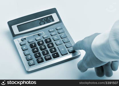 The calculator and a hand of the man. Pressing of a key of the calculator