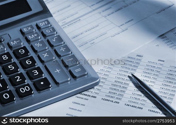 The calculator and the financial report. A workplace of the businessman. High contrast