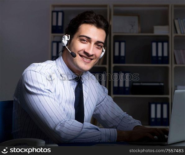 The call center operator talking to customer during night shift. Call center operator talking to customer during night shift