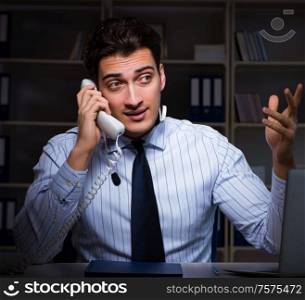 The call center operator talking to customer during night shift. Call center operator talking to customer during night shift