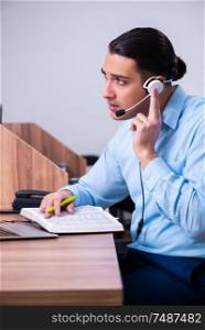 The call center operator working at his desk. Call center operator working at his desk