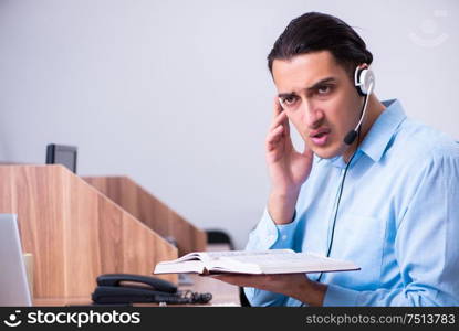 The call center operator working at his desk. Call center operator working at his desk