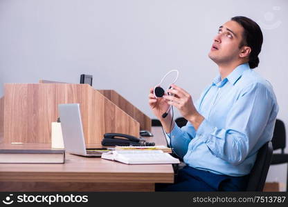 The call center operator working at his desk. Call center operator working at his desk